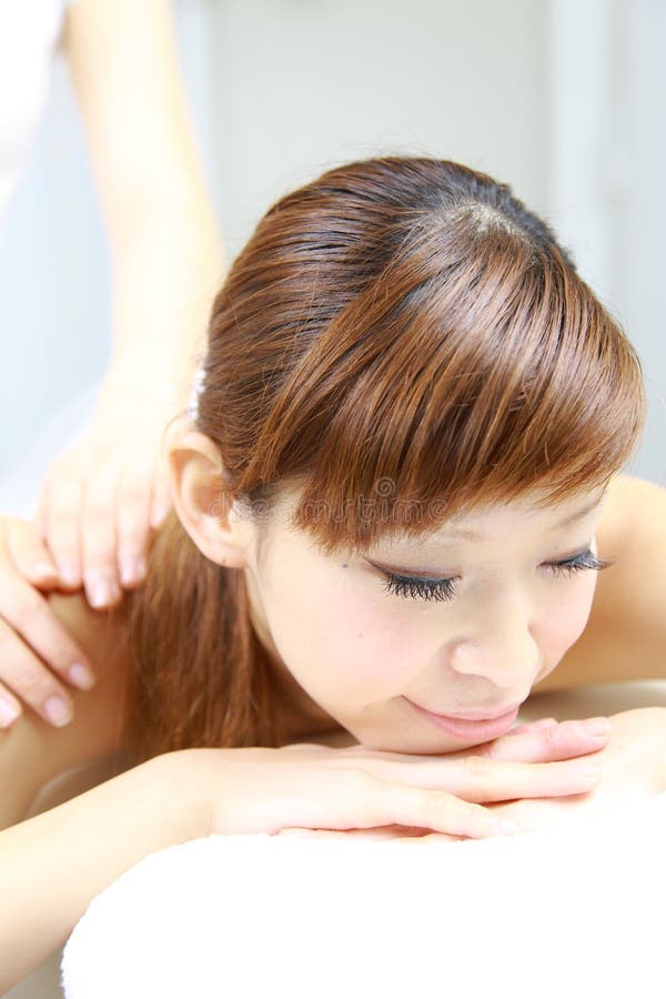 Ung japansk massage för kvinnarecevesskuldra fotografering för bildbyråer Ung japansk massage för kvinnarecevesskuldra fotografering för bildbyråer