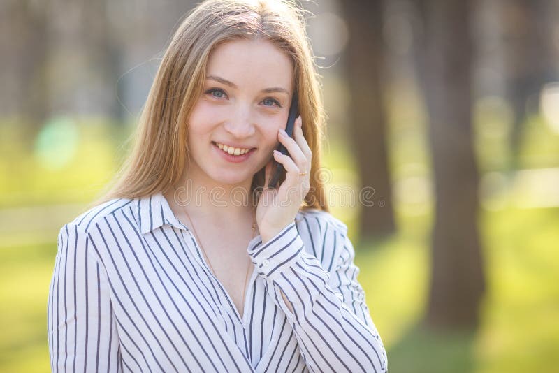 Ung kontorskvinna som utomhus talar på den smarta telefonen konversation arkivfoton Ung kontorskvinna som utomhus talar på den smarta telefonen konversation arkivfoton