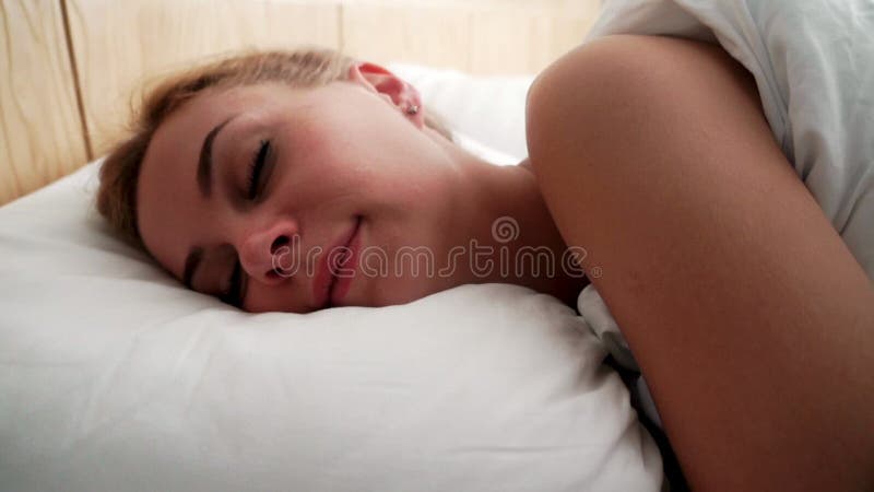 Ung kvinna för stående som sover i säng Closeupkvinna som sover på kudden arkivfilmer