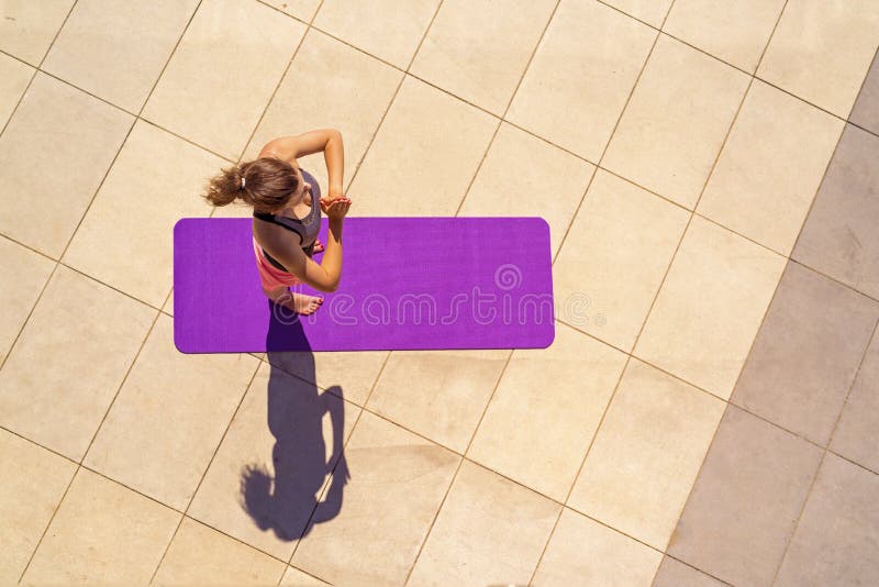 Ung kvinna i yogaposition i den soliga dagen som är utomhus-, sikt från ab royaltyfri fotografi Ung kvinna i yogaposition i den soliga dagen som är utomhus-, sikt från ab royaltyfri fotografi