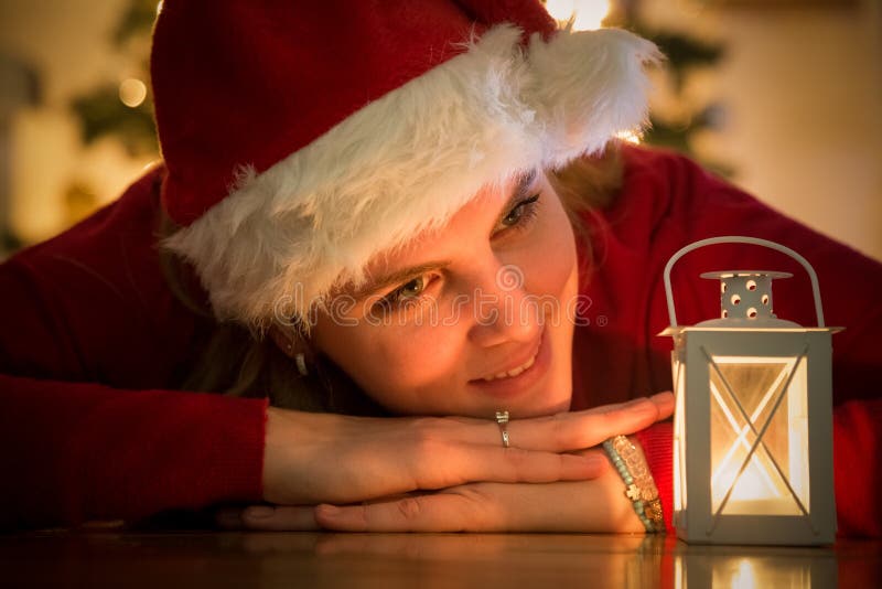 Ung kvinna med den santa hatten och vitlyktan Julfilial och klockor royaltyfri bild Ung kvinna med den santa hatten och vitlyktan Julfilial och klockor royaltyfri bild