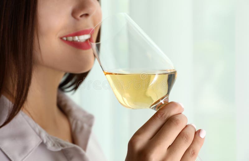 Ung kvinna med exponeringsglas av lyxigt vitt vin inomhus, closeup arkivfoto Ung kvinna med exponeringsglas av lyxigt vitt vin inomhus, closeup arkivfoto