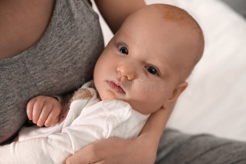 Ung kvinna med sitt lilla barn som vilar efter amning arkivfoto