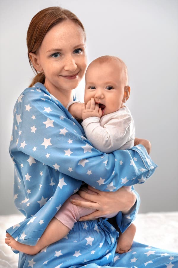 Ung kvinna med sitt lilla barn som vilar efter amning arkivfoto