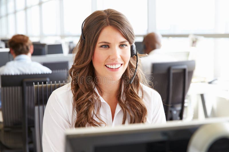 Ung kvinna som arbetar i en call center som ser skärmen fotografering för bildbyråer Ung kvinna som arbetar i en call center som ser skärmen fotografering för bildbyråer
