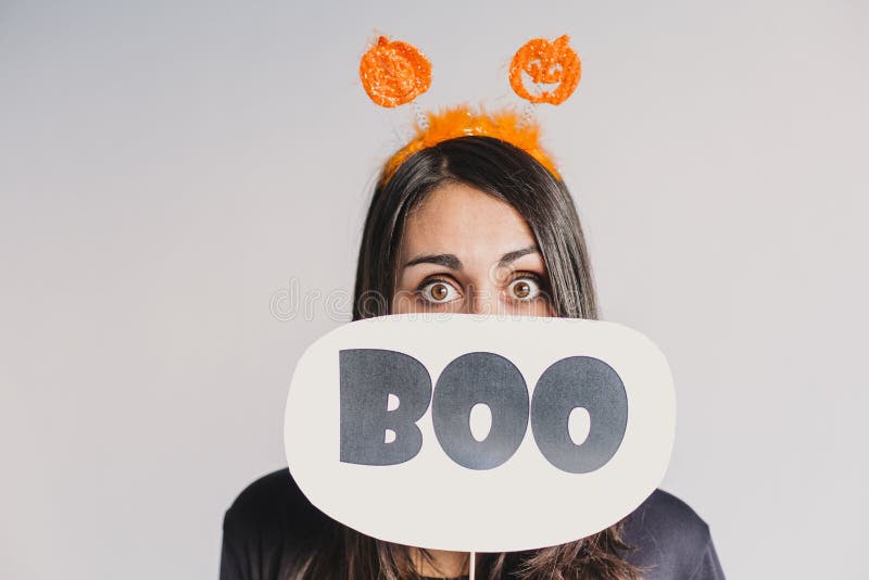 Ung kvinna som har ett boo-tecken. Med ett svart och vitt skelett. f? r den grymma s? ger miniatyrreaperen halloween f? r kalenderbeg arkivbild