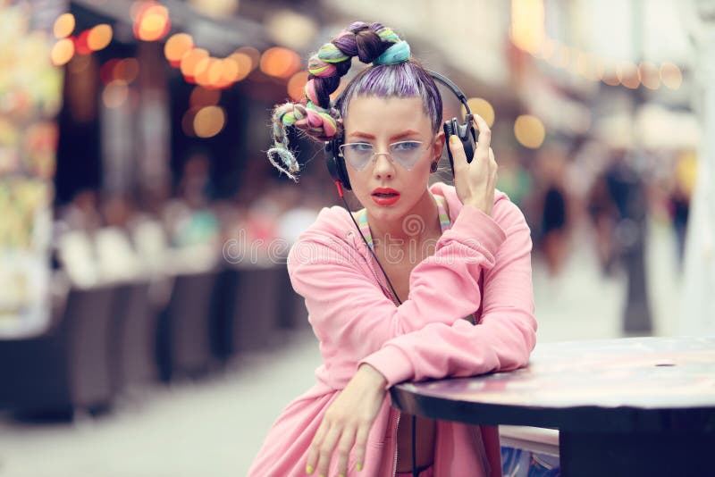 Ung kvinna som lyssnar på musik via hörlurar på gatan - Hipster Girl med ett nonkonformistiskt modeutseende fotografering för bildbyråer Ung kvinna som lyssnar på musik via hörlurar på gatan - Hipster Girl med ett nonkonformistiskt modeutseende fotografering för bildbyråer