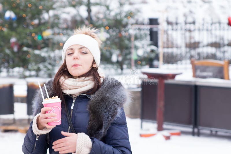Ung kvinna som tycker om en varm drink i vinter