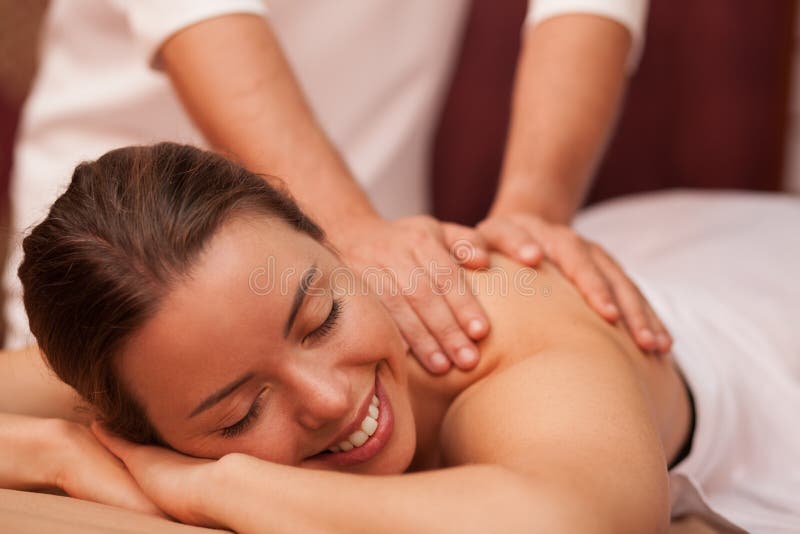 Ung kvinna som tycker om yrkesmässig massage royaltyfria bilder Ung kvinna som tycker om yrkesmässig massage royaltyfria bilder
