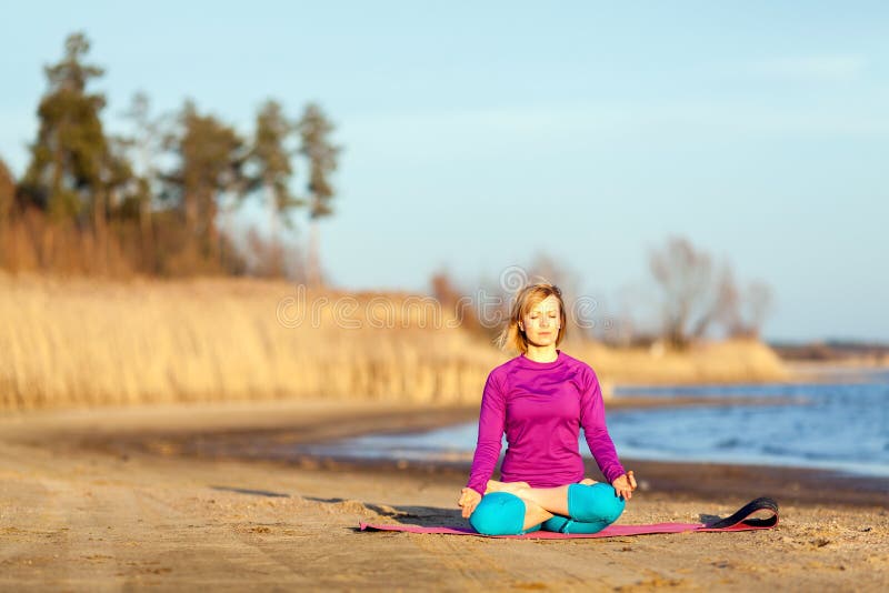 Ung kvinna som övar yoga på solnedgång royaltyfria foton Ung kvinna som övar yoga på solnedgång royaltyfria foton