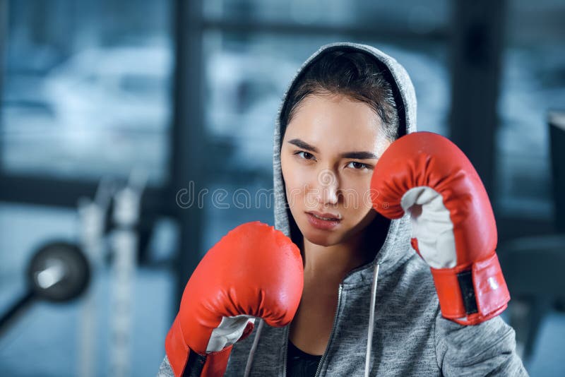 ung kvinnlig boxare i handskar som ser kameran