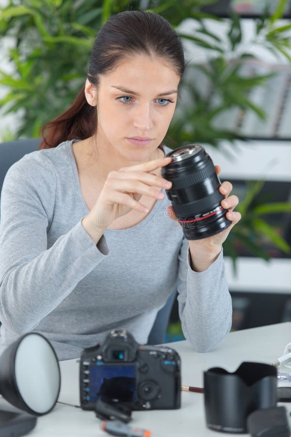 Ung kvinnlig fotograf som kontrollerar den digitala kameran royaltyfri foto Ung kvinnlig fotograf som kontrollerar den digitala kameran royaltyfri foto