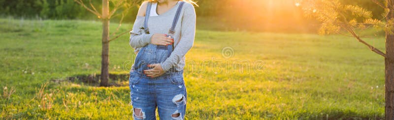 Ung lycklig gravid kvinna som kopplar av och tycker om liv i höstnatur