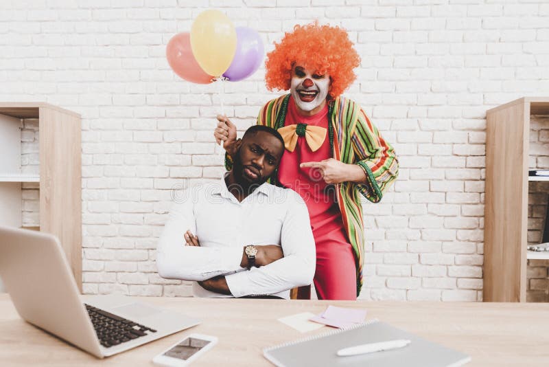 Ung man i clownen Costume med Baloons i regeringsställning royaltyfria foton Ung man i clownen Costume med Baloons i regeringsställning royaltyfria foton