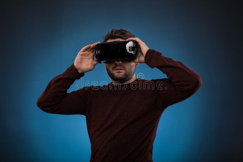 Ung man med virtuell verklighethörlurar med mikrofon eller exponeringsglas 3d över blått arkivbilder Ung man med virtuell verklighethörlurar med mikrofon eller exponeringsglas 3d över blått arkivbilder