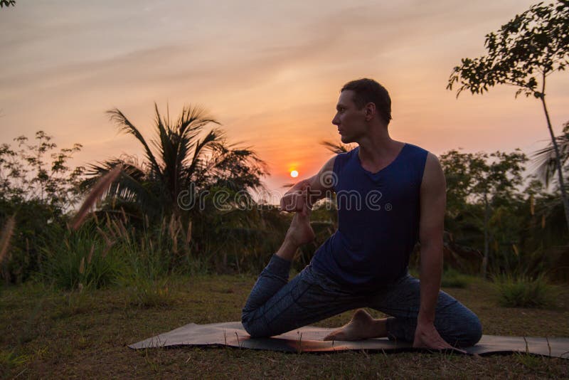 ung man som gör yoga nära palmträdet på solnedgången arkivfoton ung man som gör yoga nära palmträdet på solnedgången arkivfoton