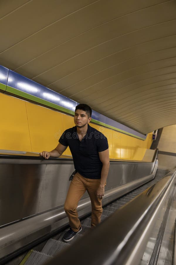 Ung man som klättrar rulltrapporna av gångtunnelstationen royaltyfri fotografi Ung man som klättrar rulltrapporna av gångtunnelstationen royaltyfri fotografi