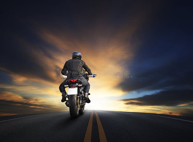 Young man riding big bike motocycle on asphalt high way against beautiful dusky sky use for biker traveling and journey theme. Young man riding big bike motocycle on asphalt high way against beautiful dusky sky use for biker traveling and journey theme