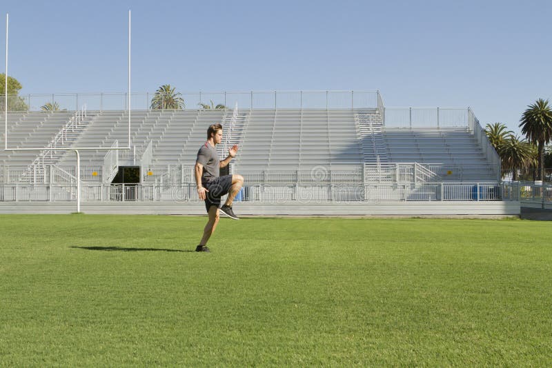 A Caucasian man in his twenties works out at a stadium. A Caucasian man in his twenties works out at a stadium.