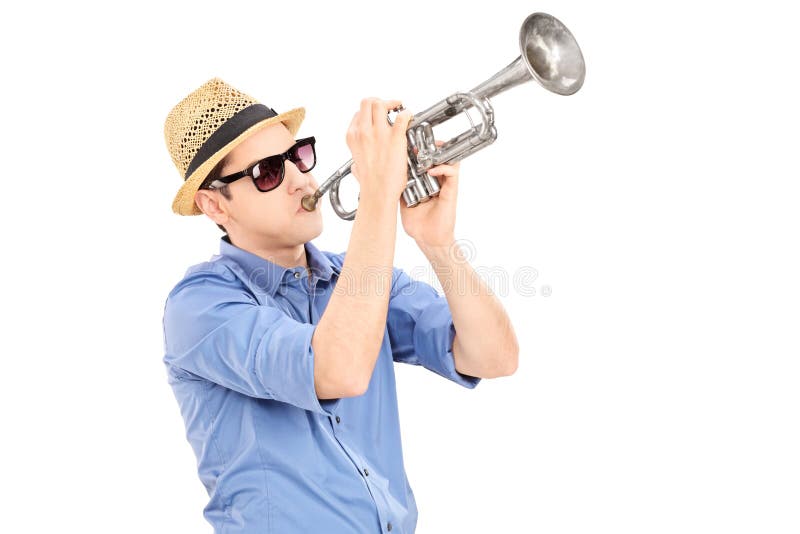Ung manlig musiker som blåser in i en trumpet