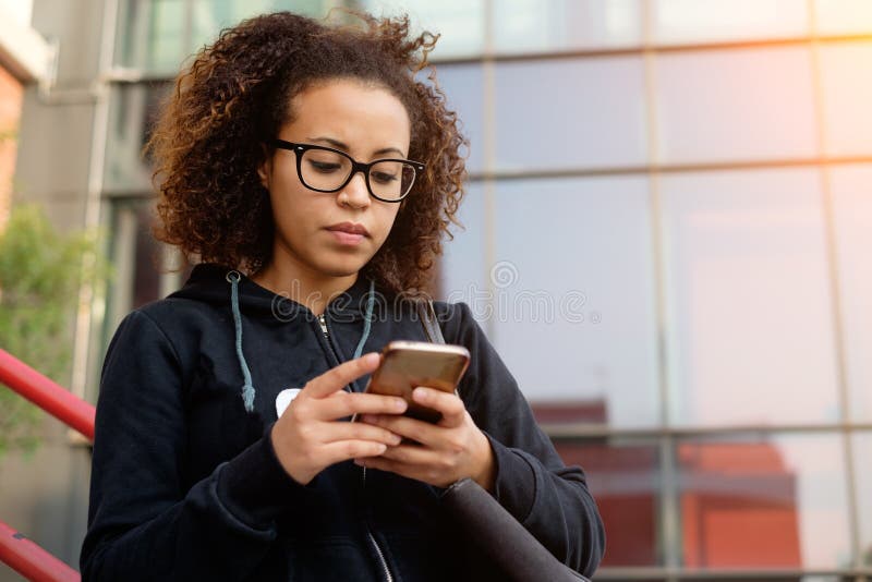 Ung millennial flicka som smsar på hennes telefon fotografering för bildbyråer Ung millennial flicka som smsar på hennes telefon fotografering för bildbyråer