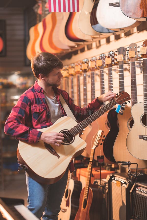 Ung musiker med en gitarr inomhus royaltyfria foton
