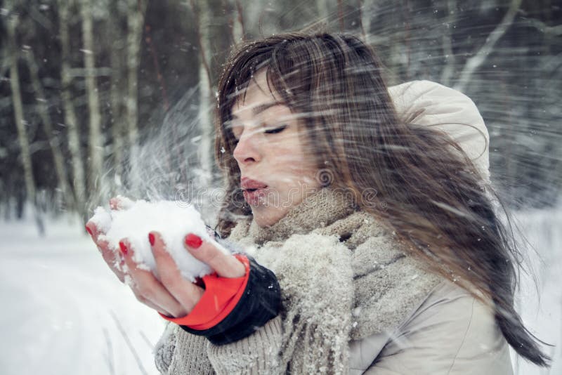 Ung nätt kvinna som har gyckel i vinterskogen i rörelse arkivfoto Ung nätt kvinna som har gyckel i vinterskogen i rörelse arkivfoto