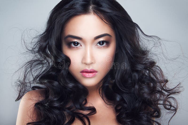 Ung och härlig asiatisk kvinna med lockigt hår