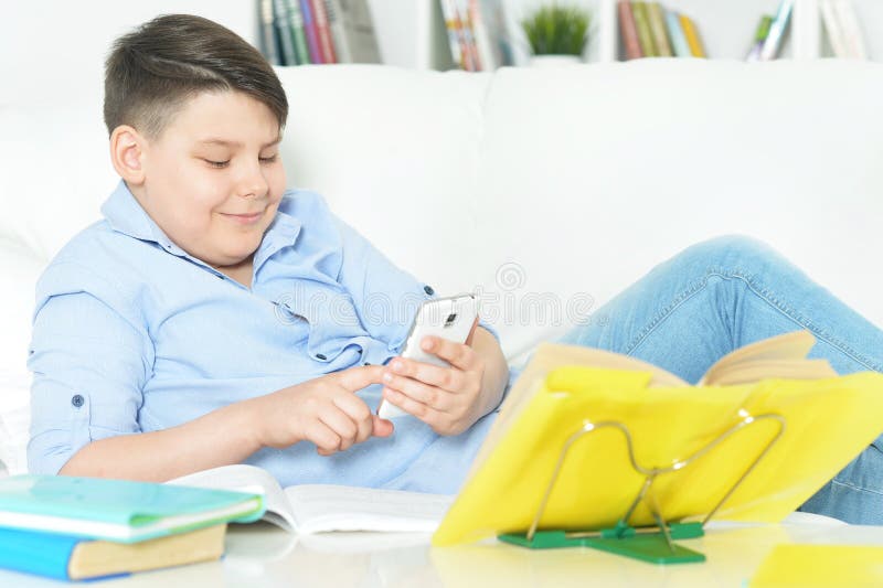 Ung pojke med smartphone-spel royaltyfri bild