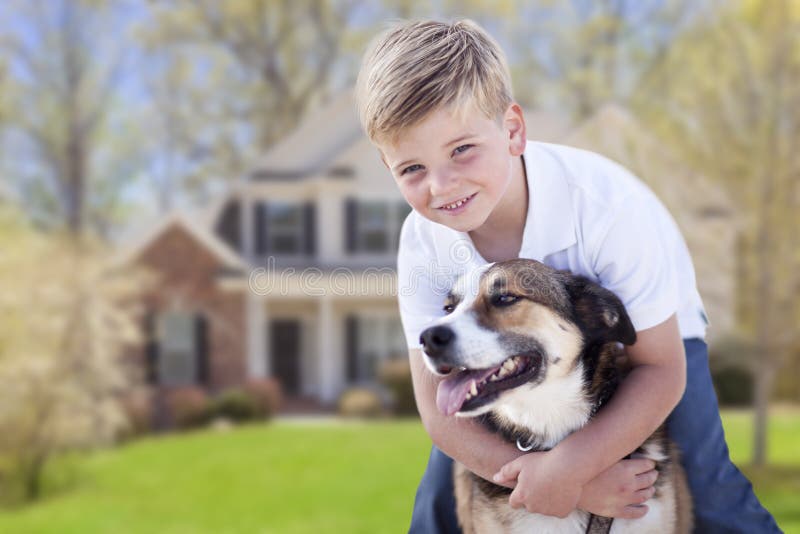 Ung pojke och hans hund framme av huset royaltyfria foton Ung pojke och hans hund framme av huset royaltyfria foton