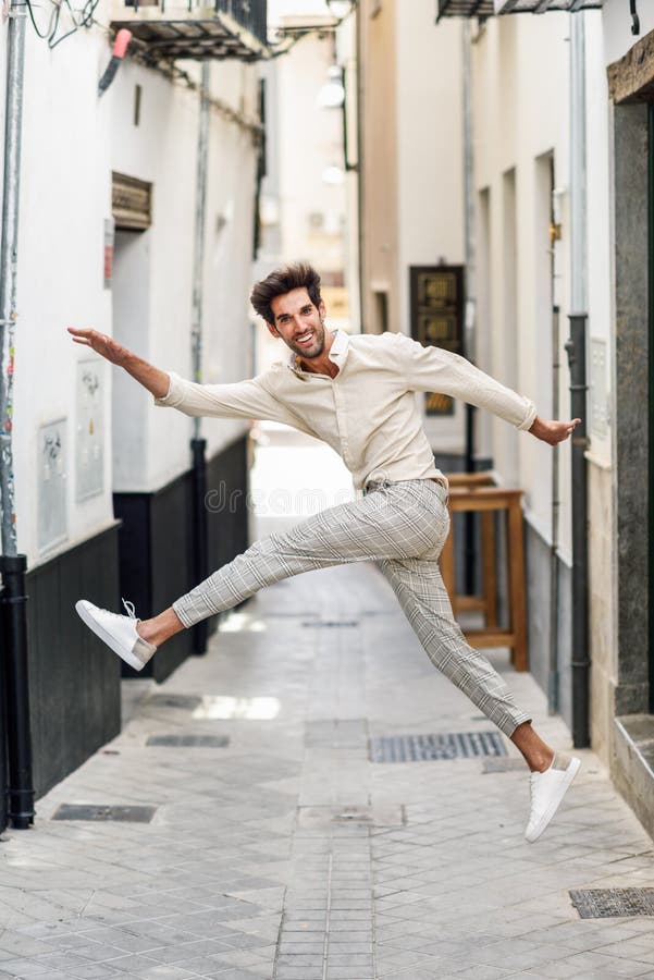 Young funny man jumping in the street. Attractive Guy wearing casual clothes in urban background. Young funny man jumping in the street. Attractive Guy wearing casual clothes in urban background.