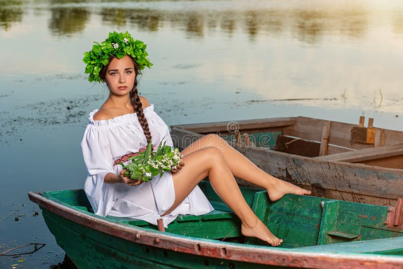 Ung sexig kvinna på fartyget på solnedgången Flickan har en blommakrans på hennes huvud som kopplar av och seglar på floden Fanta arkivfoto Ung sexig kvinna på fartyget på solnedgången Flickan har en blommakrans på hennes huvud som kopplar av och seglar på floden Fanta arkivfoto