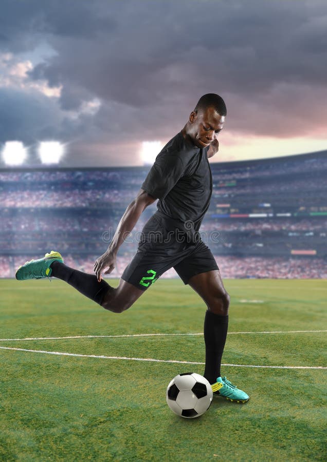 Ung sparkande fotboll för afrikansk amerikanfotbollspelare royaltyfri bild Ung sparkande fotboll för afrikansk amerikanfotbollspelare royaltyfri bild