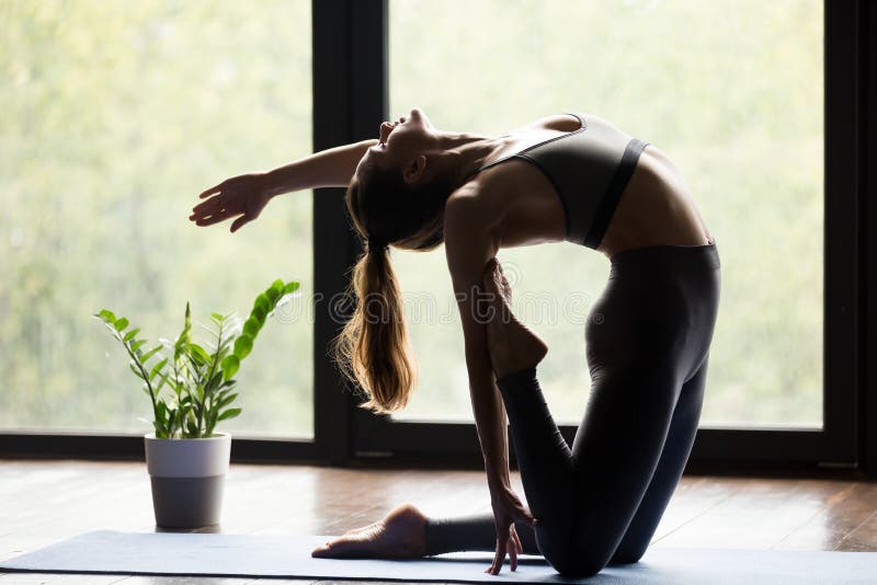 Ung sportig kvinna som gör Ustrasana backbendövning fotografering för bildbyråer Ung sportig kvinna som gör Ustrasana backbendövning fotografering för bildbyråer