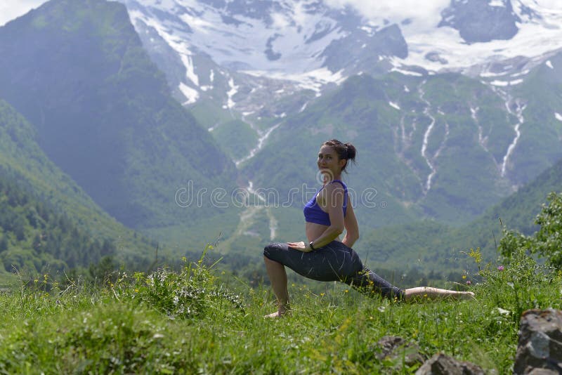 Ung sportkvinna som gör yoga på det gröna gräset i sommaren fotografering för bildbyråer Ung sportkvinna som gör yoga på det gröna gräset i sommaren fotografering för bildbyråer