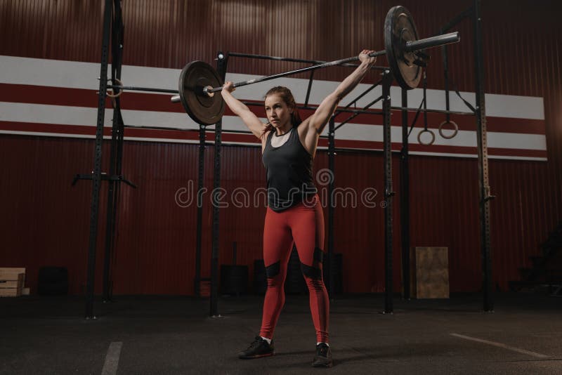 Ung stark kvinna som rymmer tung skivstångfast utgift Sportkvinna som gör crossfitövning arkivfoto Ung stark kvinna som rymmer tung skivstångfast utgift Sportkvinna som gör crossfitövning arkivfoto