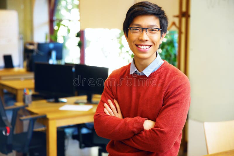 Ung stilig asiatisk man med vikta armar fotografering för bildbyråer Ung stilig asiatisk man med vikta armar fotografering för bildbyråer