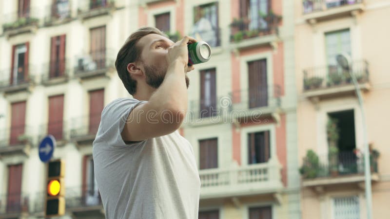 Ung, stilig kaukasisk man som dricker dryck på den europeiska gatan stock video