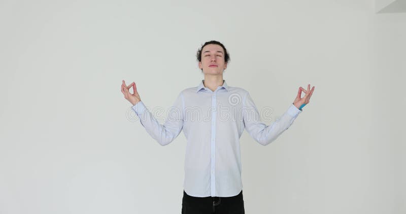 Ung, stilig man avslappnad och log med meditationsgest med fingrar på vit bakgrund lager videofilmer