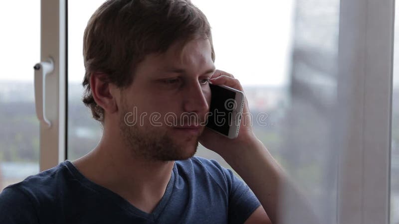 Ung stilig man som dricker te och talar på mobil lager videofilmer