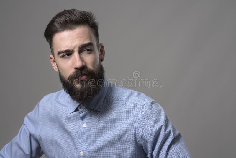 Ung stilig skäggig stilfull säker hipster som tillbaka ser över skuldran på copyspace royaltyfria foton Ung stilig skäggig stilfull säker hipster som tillbaka ser över skuldran på copyspace royaltyfria foton