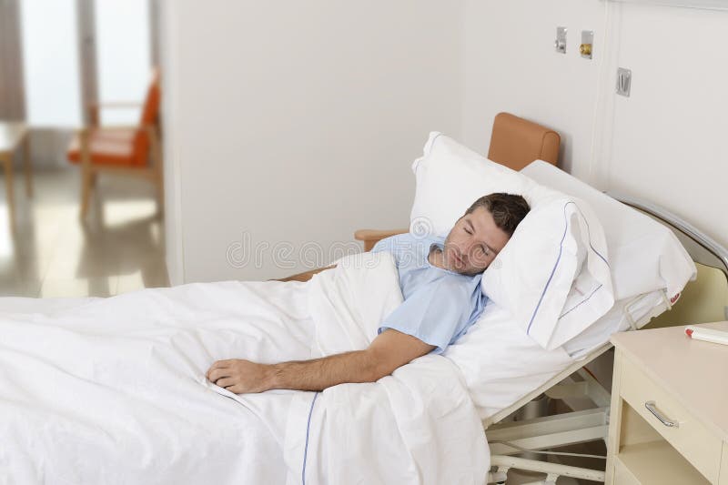 Ung tålmodig man som ligger på sjukhussäng som vilar och sover ha allvarligt medicinskt villkor arkivbilder Ung tålmodig man som ligger på sjukhussäng som vilar och sover ha allvarligt medicinskt villkor arkivbilder