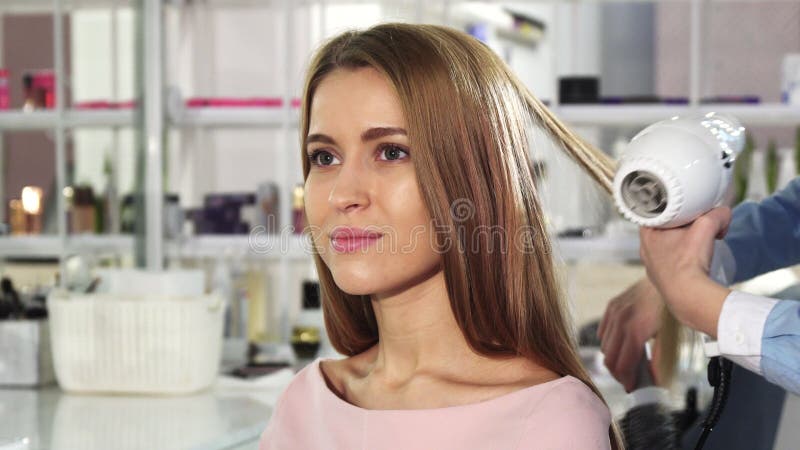 Ung ursnygg kvinna som får henne hår färgat av en yrkesmässig frisör