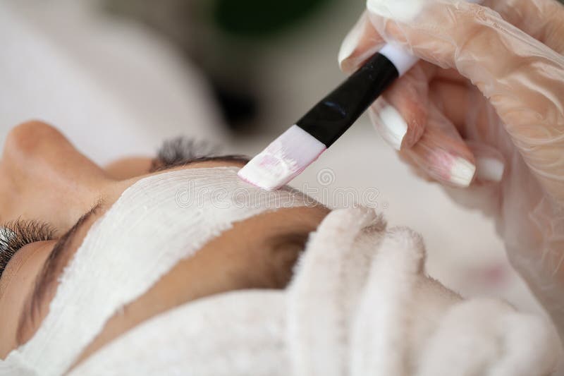 Ung vacker flicka som får ansiktsmask i spa skönhetssalon arkivfoto
