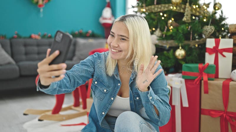 Ung, vacker historisk kvinna som firar att jultomte har videosamtal hemma royaltyfri foto