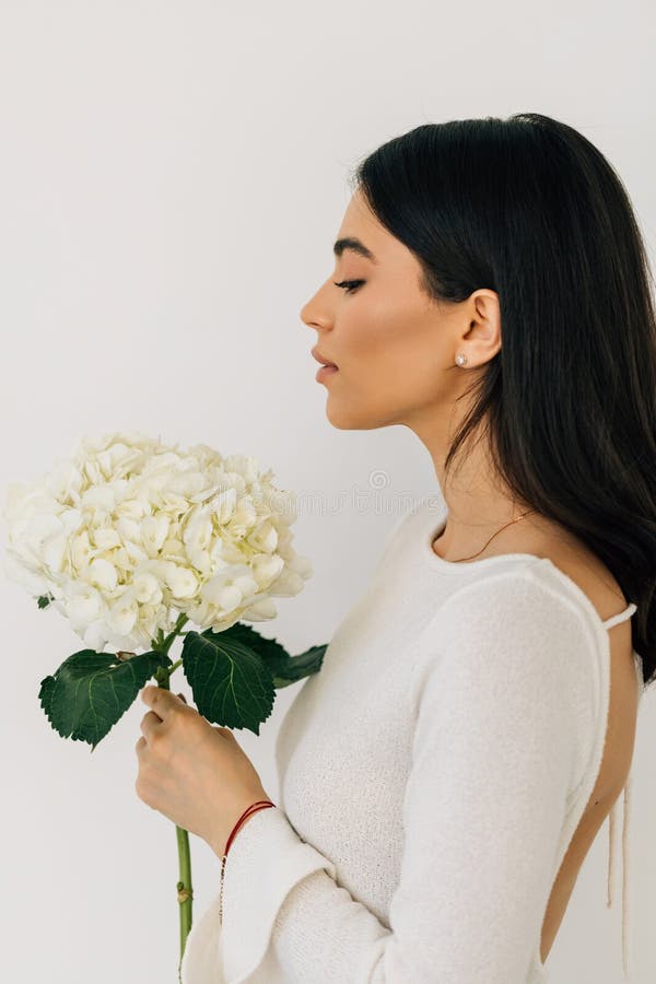 Ung vacker kvinna med blommor nära ansiktet. skönhetsvård. hudvård arkivbild