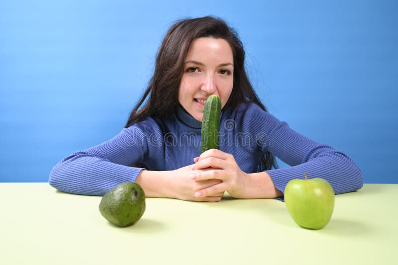 Ung vacker kvinna som håller gurka i händerna. vegetariankoncept. arkivfoton