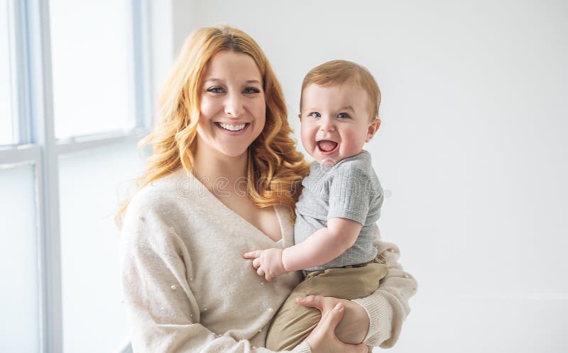 Ung, vacker mor med en babypojke i studio arkivbilder