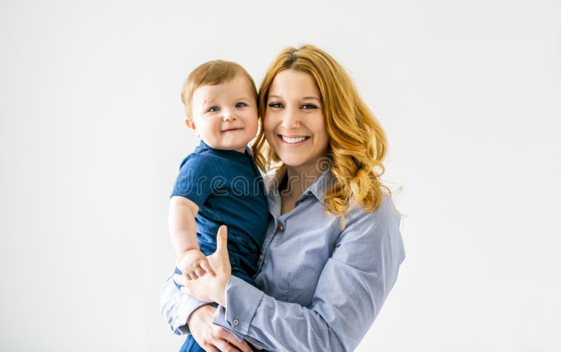 Ung, vacker mor med en babypojke i studio arkivbilder