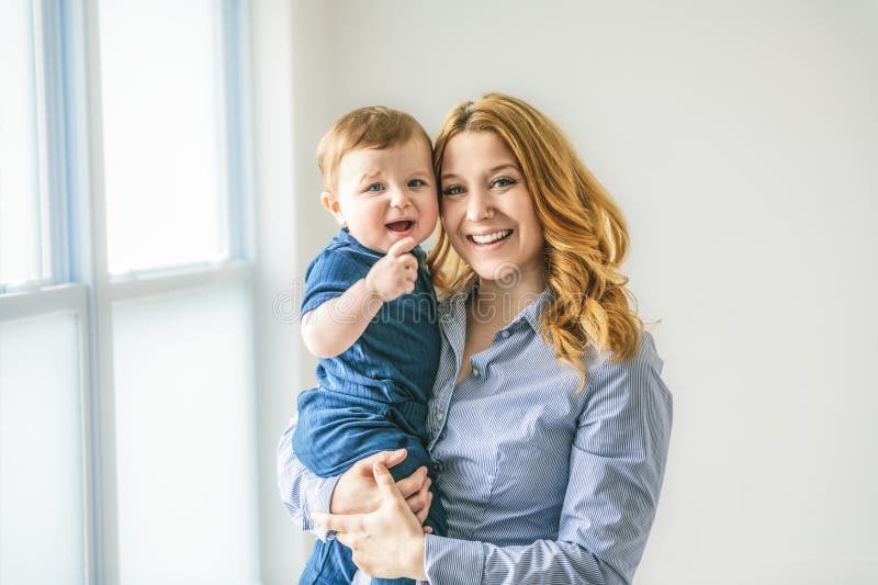 Ung, vacker mor med en babypojke i studio royaltyfri bild